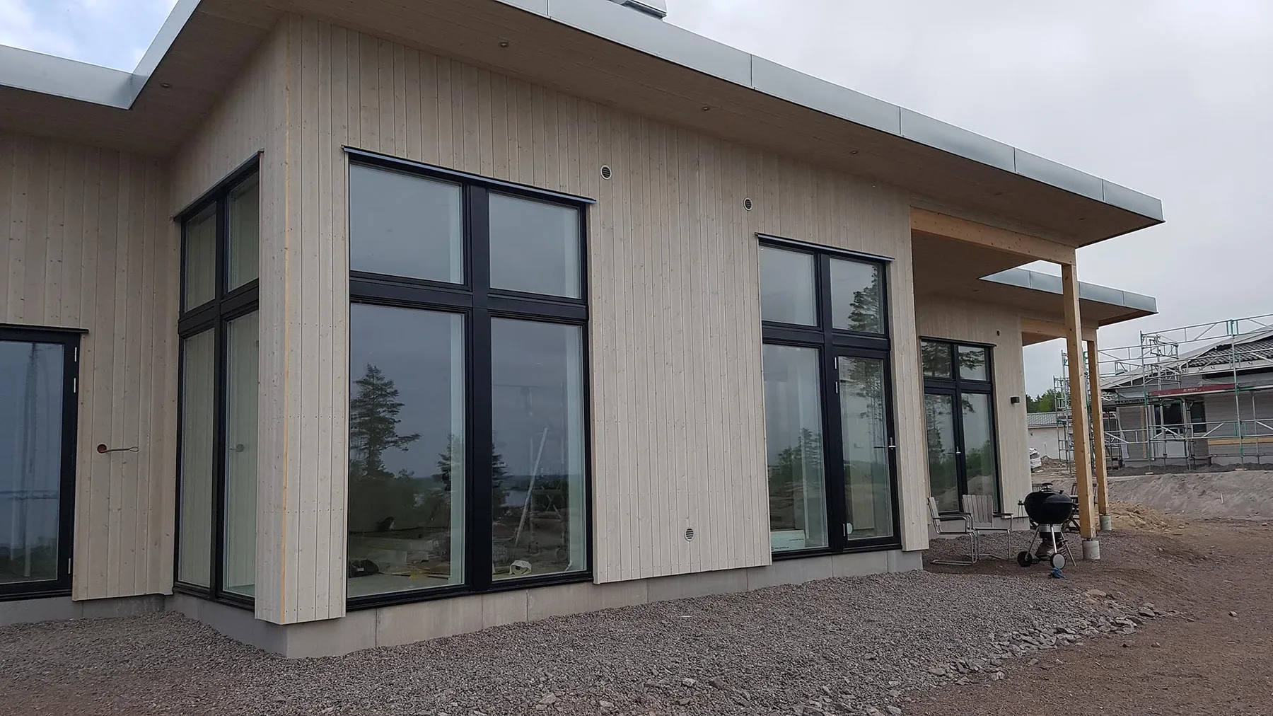 Modern byggnad i trä med stora fönster och plåtdetaljer