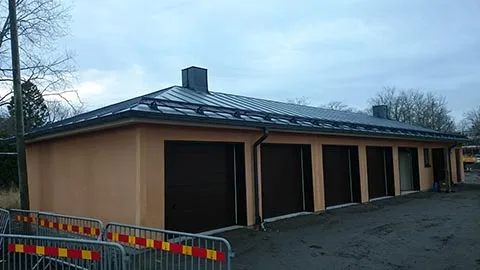 Garage med mörkt bandtäckt plåttak