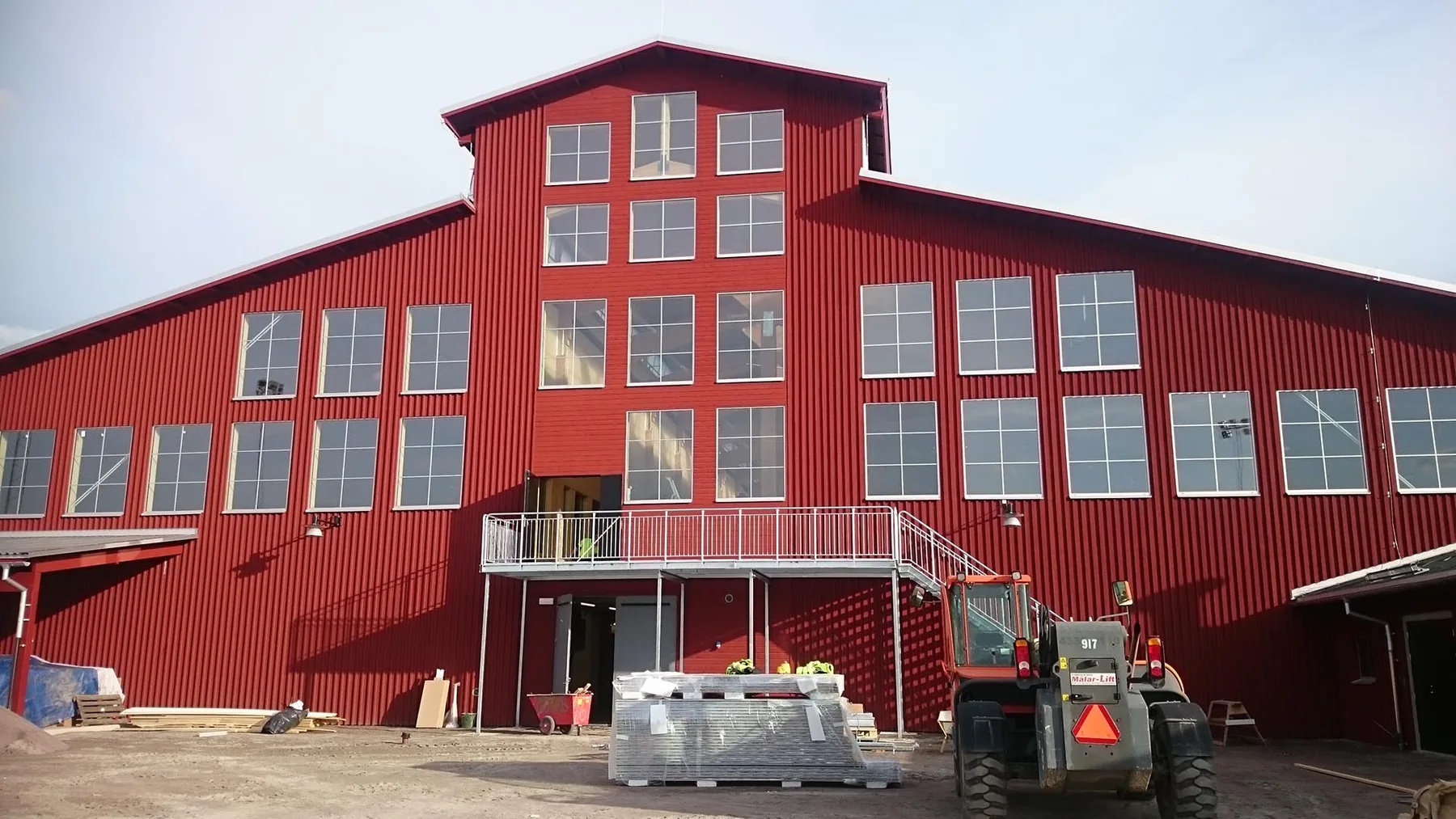 Nybyggd röd industrihall med plåttak och plåtfasad